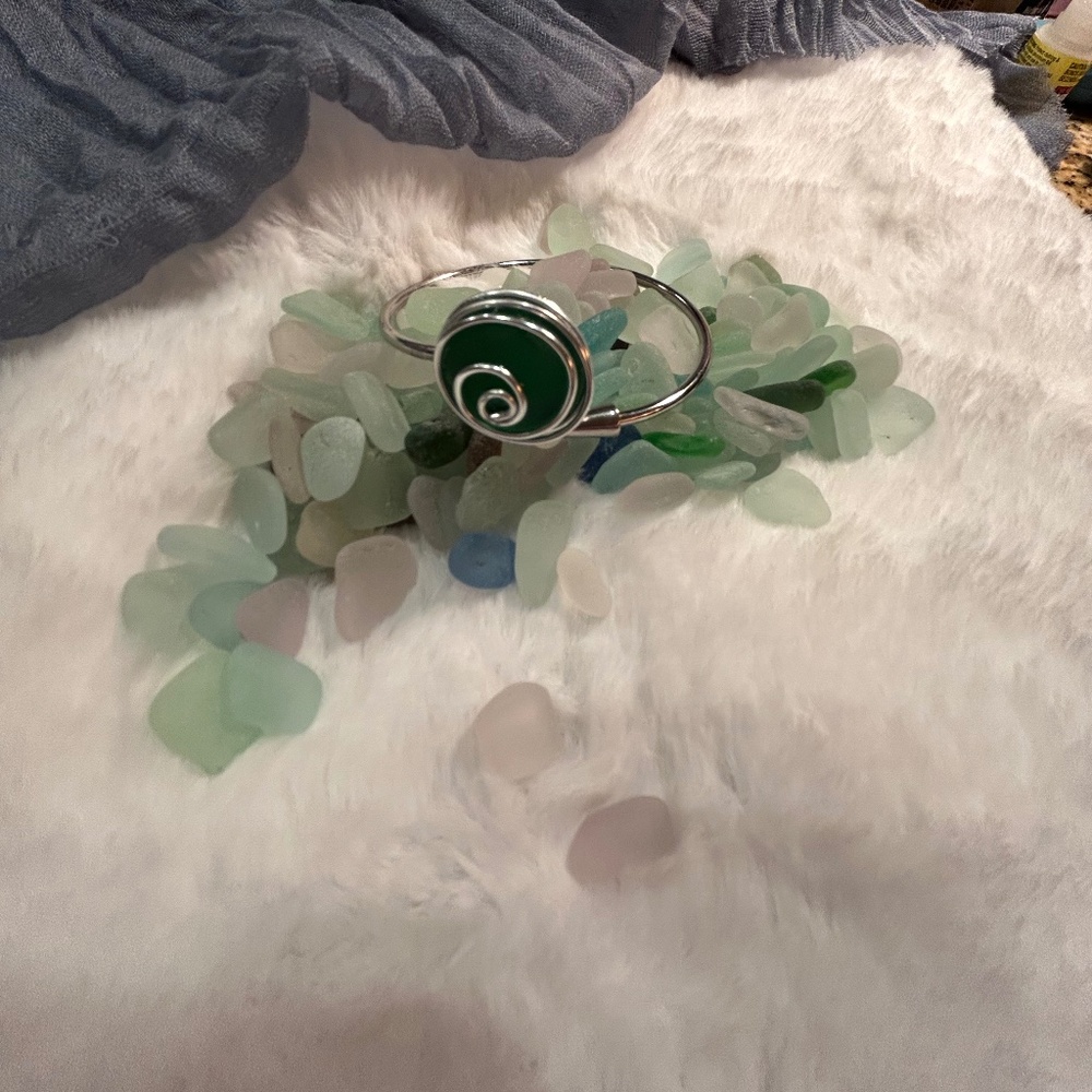 Glass bangle bracelet with wire trim.